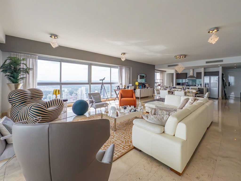 Sala de apartamento en Yoo Panama con vista panorámica a la ciudad y mobiliario de diseño contemporáneo